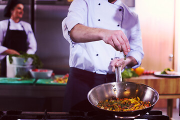 Image showing chef putting spices on vegetables in wok