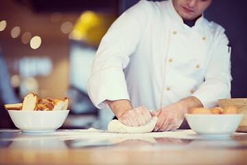 Image showing young chef preparing dough for pizza