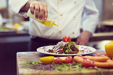 Image showing Chef finishing steak meat plate