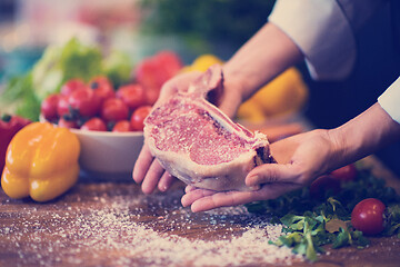 Image showing Chef holding juicy slice of raw steak