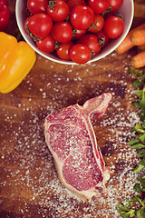 Image showing top view of raw steak on wooden table