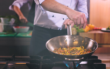 Image showing chef putting spices on vegetables in wok