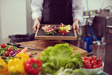 Image showing female Chef holding beef steak plate