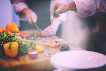 Image showing Chef hands preparing marinated Salmon fish