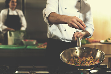 Image showing chef putting spices on vegetables in wok