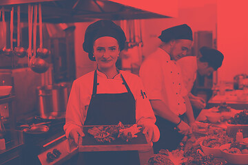 Image showing female Chef holding beef steak plate