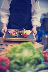 Image showing female Chef holding beef steak plate