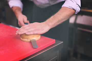 Image showing chef hands cutting rolls for burger