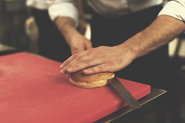 Image showing chef hands cutting rolls for burger