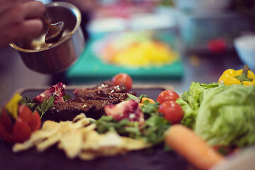 Image showing Chef hand finishing steak meat plate