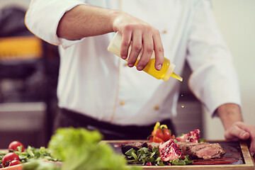 Image showing Chef finishing steak meat plate