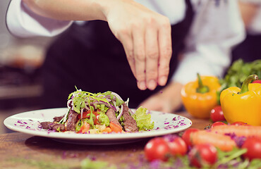 Image showing cook chef decorating garnishing prepared meal