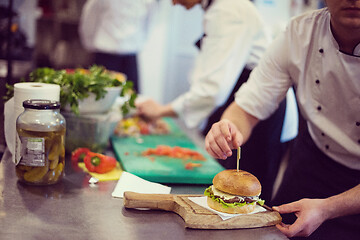 Image showing chef finishing burger