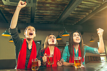 Image showing Sport, people, leisure, friendship and entertainment concept - happy football fans or female friends drinking beer and celebrating victory at bar or pub