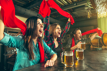 Image showing Sport, people, leisure, friendship and entertainment concept - happy football fans or female friends drinking beer and celebrating victory at bar or pub