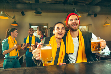 Image showing Sport, people, leisure, friendship and entertainment concept - happy football fans or male friends drinking beer and celebrating victory at bar or pub