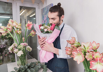 Image showing Small business. Male florist in flower shop. Floral design studio, making decorations and arrangements.