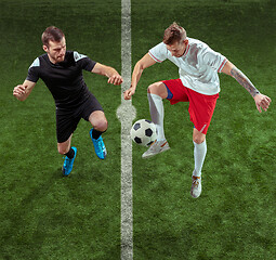 Image showing Football players tackling ball over green grass background