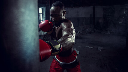 Image showing Hand of boxer over black background. Strength, attack and motion concept