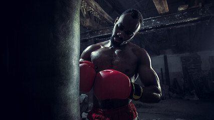 Image showing Hand of boxer over black background. Strength, attack and motion concept