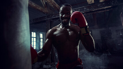 Image showing Hand of boxer over black background. Strength, attack and motion concept