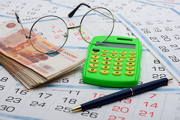 Image showing Money, calculator, glasses and pen are on the calendar