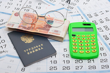 Image showing Business still life from a bundle of five thousandth bills, a calculator, glasses and a work book