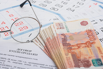 Image showing Sale and purchase agreement of an apartment, a wad of money, a calendar and glasses