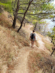 Image showing Young active feamle tourist wearing small backpack walking on co