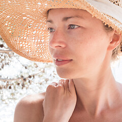 Image showing Close up portrait of no makeup natural beautiful sensual woman wearing straw sun hat on the beach in shade of a pine tree