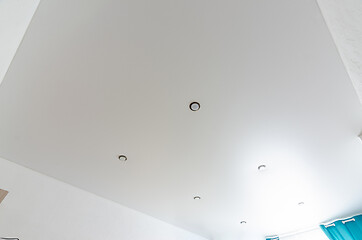 Image showing Fragment of the room\'s interior - white matte stretch ceiling with a series of spotlights