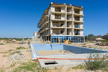 Image showing Illegal construction on the coastal side, hotel demolition, unfinished swimming pool in the foreground