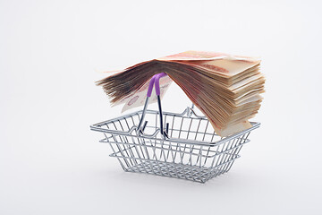 Image showing On the handles of the grocery basket is a large stack of paper bills, viewed from the side