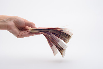 Image showing Hand holds out a wad of money, white background