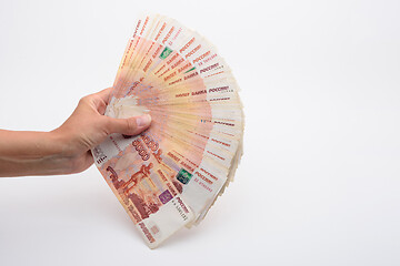 Image showing Hand fanned out the kidney of five thousandth Russian bills