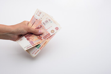 Image showing Hand holds a bundle of Russian five thousandth bills