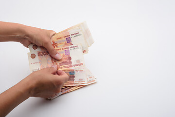 Image showing Hands count money in a bundle of five-thousandth Russian bills