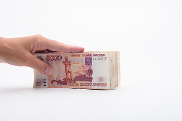 Image showing Hand holds a bundle of banknotes, five thousandth bills on a white background