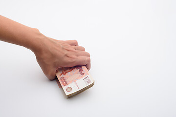 Image showing Hand takes from a white background a pack of five thousandth bills