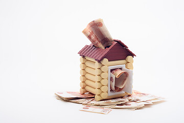 Image showing Five-thousandth Russian banknotes stick out from the windows and the door of the house, the house stands on a bundle of banknotes