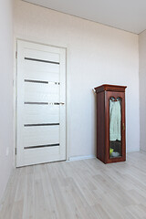 Image showing Fragment of an empty room interior with a small cabinet and a door