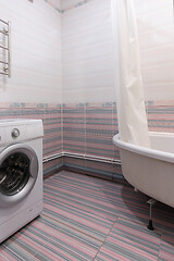 Image showing View of an empty corner in the bathroom, with a washing machine and a bathroom on the sides