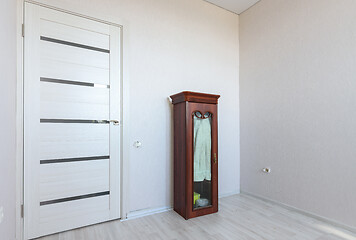 Image showing A fragment of a small bedroom in an apartment with poor furniture, a view of the front door and a locker