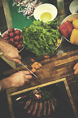 Image showing top view of Chef hands serving beef steak