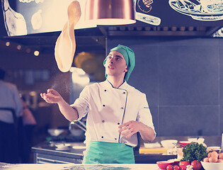 Image showing chef throwing up pizza dough