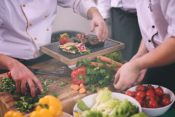 Image showing team cooks and chefs preparing meal