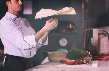 Image showing chef throwing up pizza dough