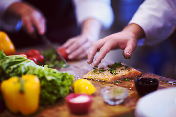 Image showing Chef hands preparing marinated Salmon fish