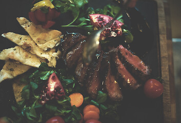 Image showing Chef hand finishing steak meat plate