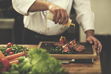 Image showing Chef finishing steak meat plate